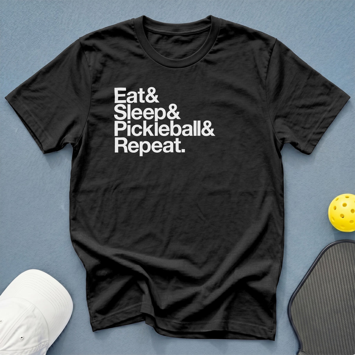 Black t-shirt with "Eat & Sleep & Pickleball & Repeat." text, pickleball, and paddle.