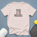 Light pink t-shirt with "PEACE LOVE PICKLEBALL" text and a pickleball graphic.
