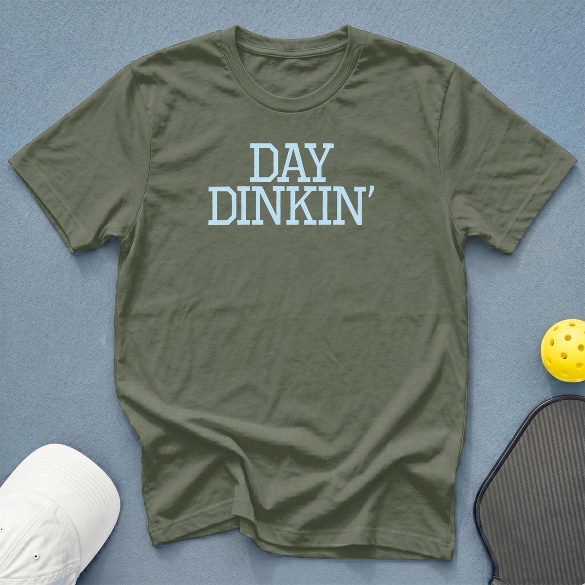Olive green t-shirt with light blue text that reads "DAY DINKIN'".