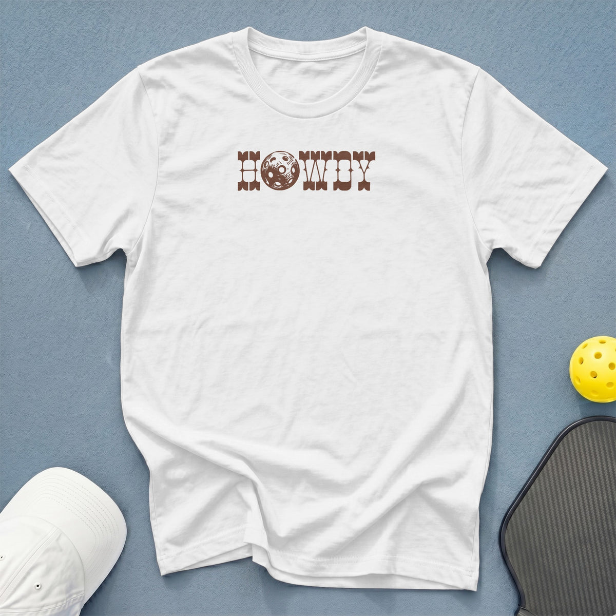 White t-shirt with brown "Howdy" text featuring a pickleball graphic.