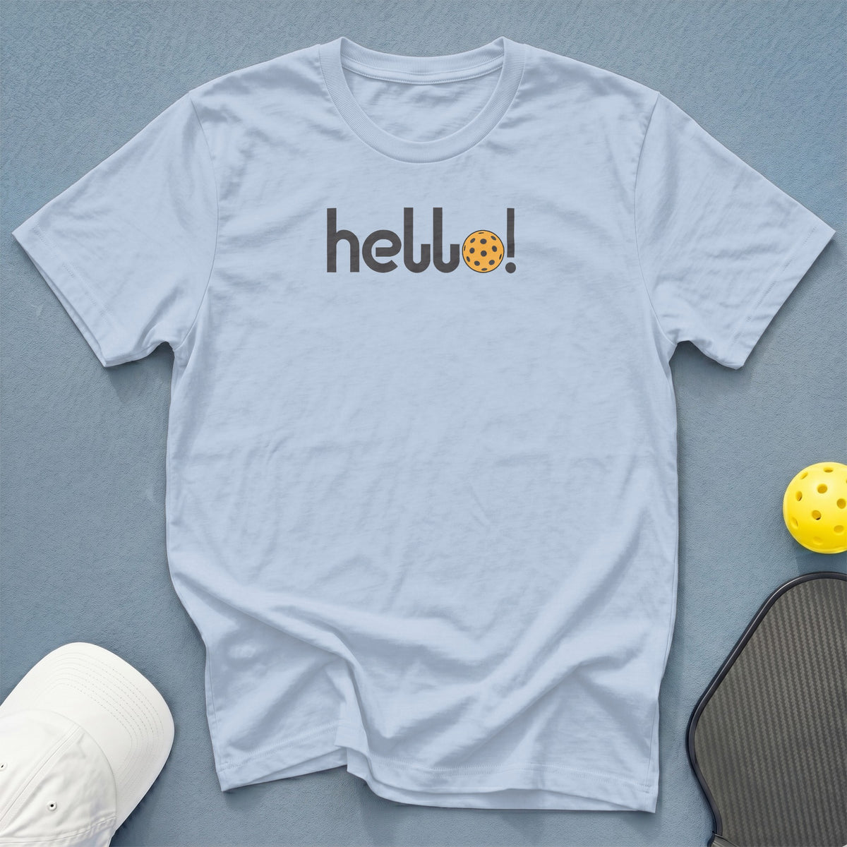 Light blue t-shirt with "hello!" text, featuring a pickleball.