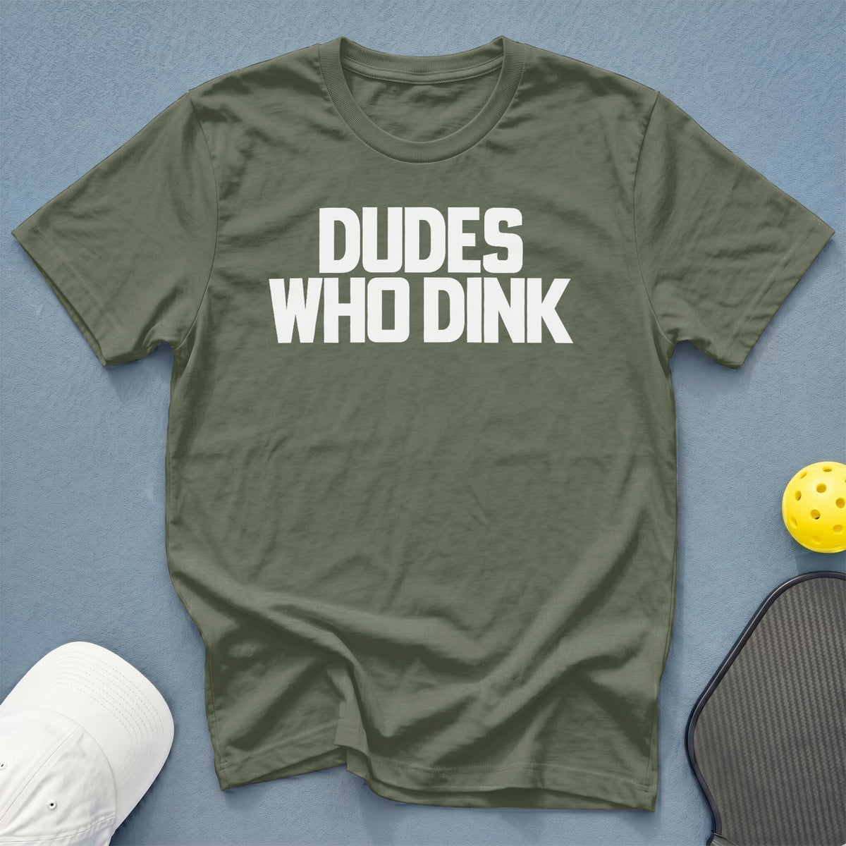 Olive green t-shirt with "DUDES WHO DINK" in white text, pickleball paddle, and ball.