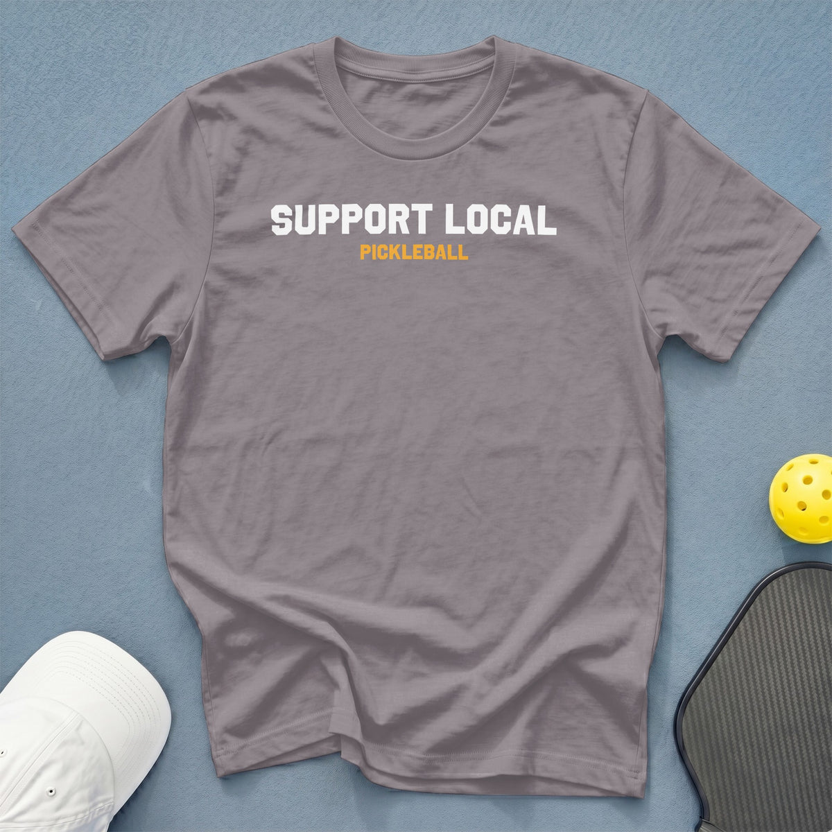 Grey t-shirt with "SUPPORT LOCAL PICKLEBALL" text, pickleball, and hat.