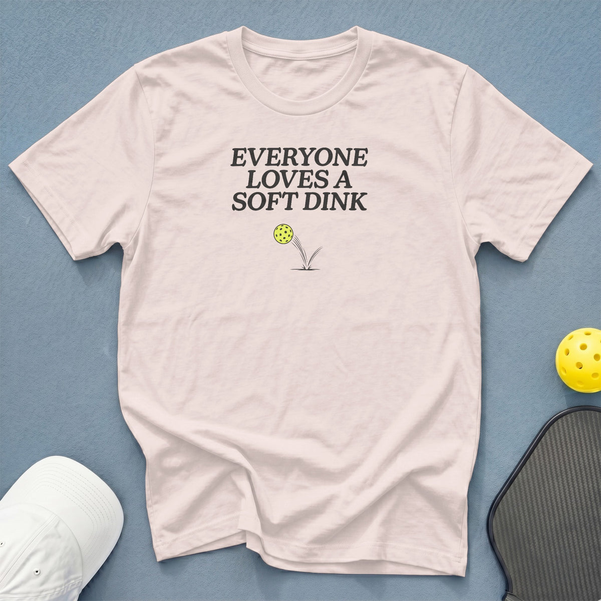 Light pink t-shirt with "EVERYONE LOVES A SOFT DINK" and pickleball graphic.