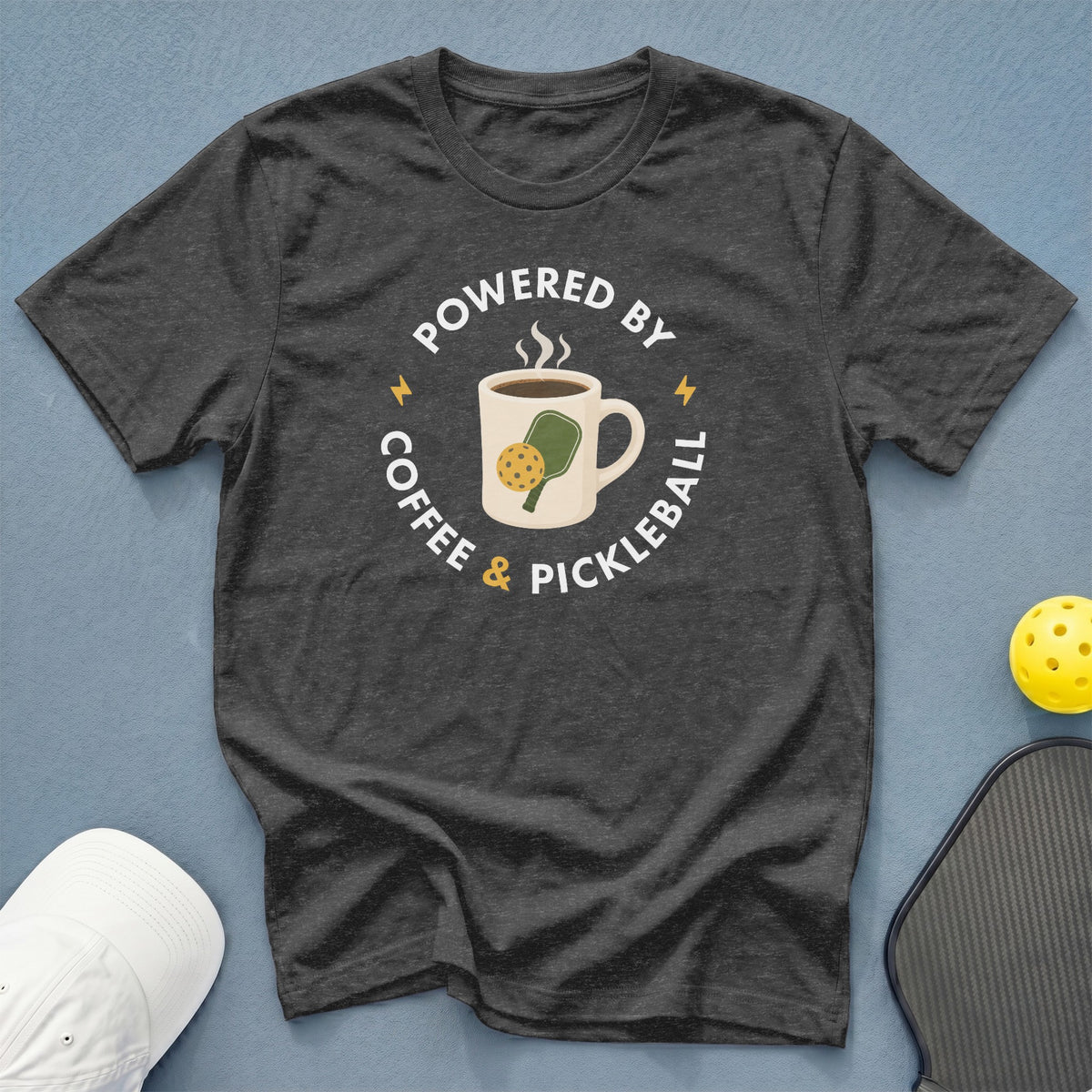 Dark grey t-shirt with "Powered by Coffee & Pickleball" text and graphics.