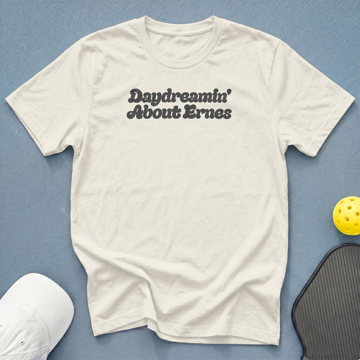Cream t-shirt with "Daydreamin' About Ernes" text, pickleball paddle, and ball.