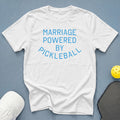 White t-shirt with blue text reading "MARRIAGE POWERED BY PICKLEBALL".