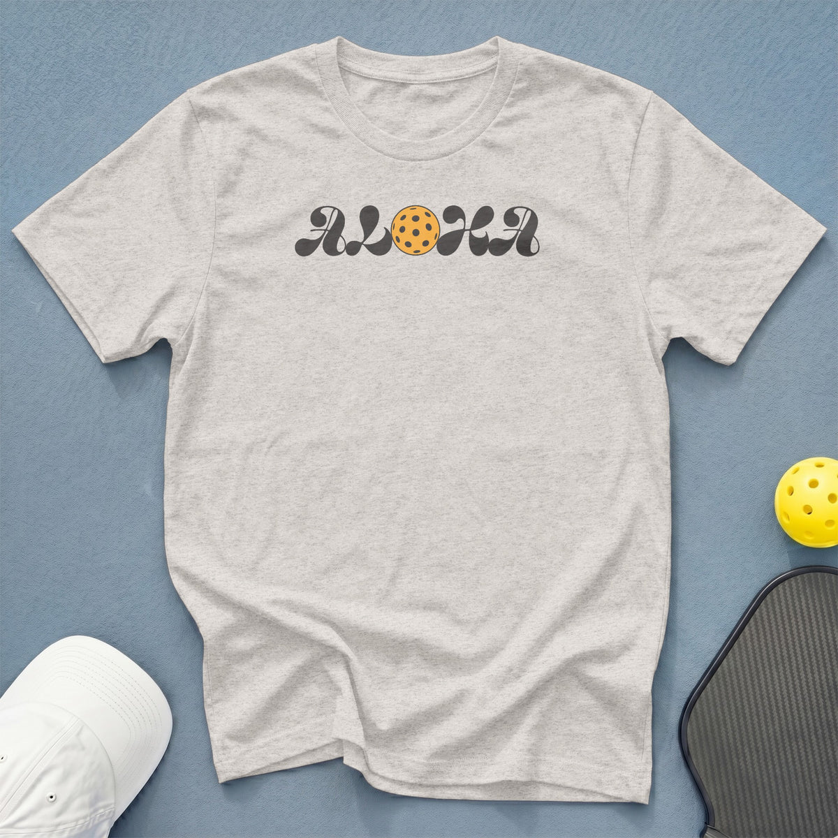 Light grey t-shirt with "ALOHA" text featuring a pickleball graphic.