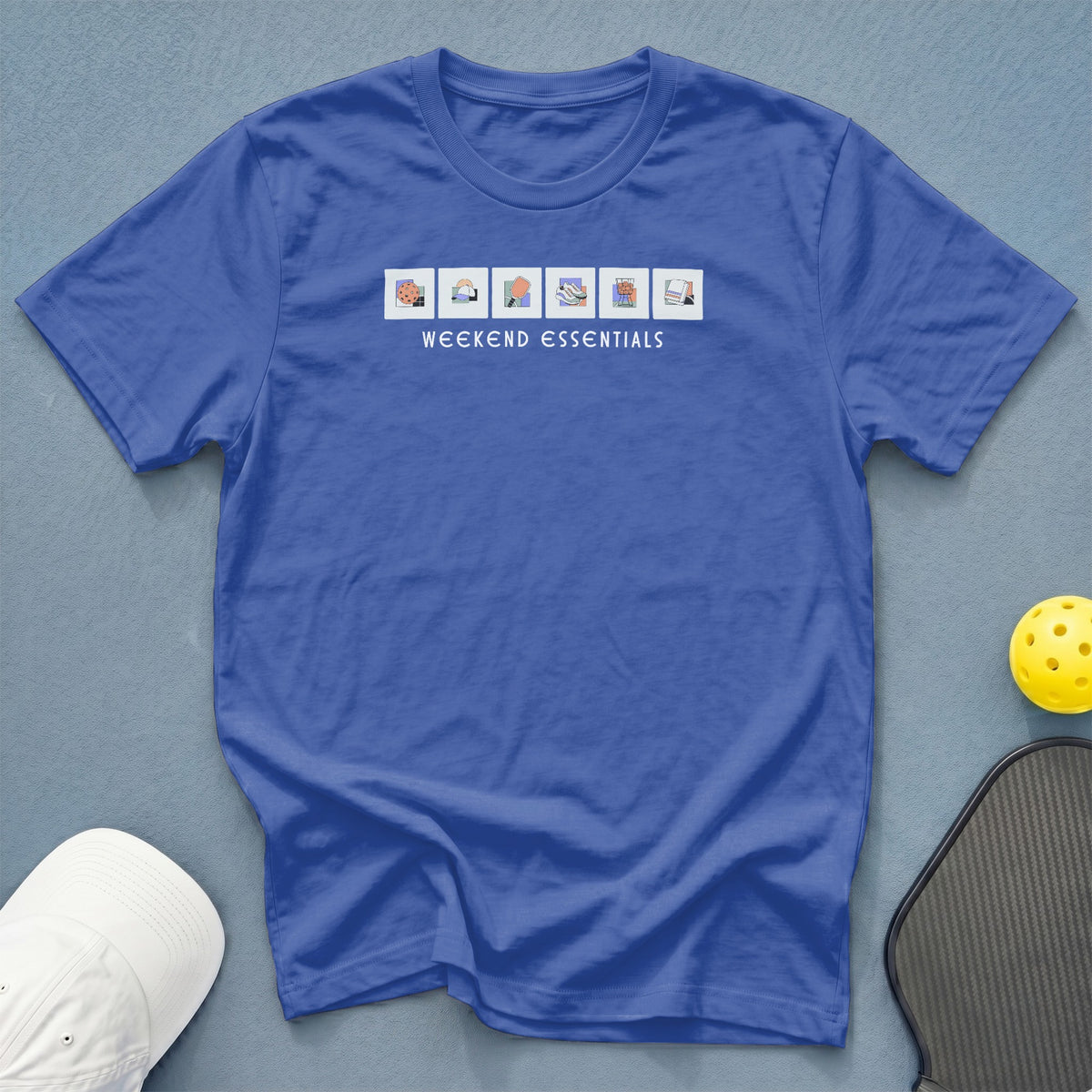 Blue t-shirt with "WEEKEND ESSENTIALS" text and illustrated items.