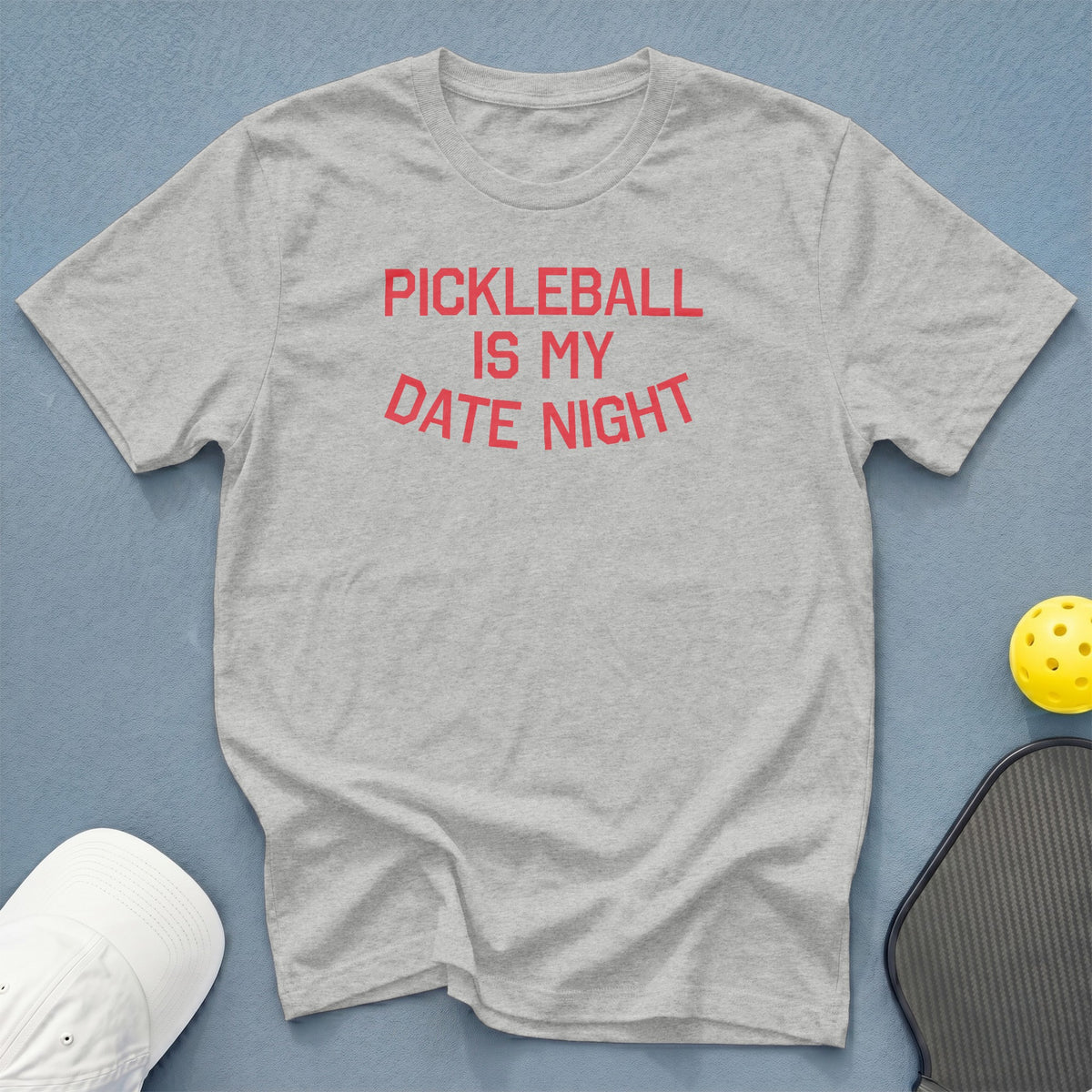 Grey t-shirt with red text "Pickleball Is My Date Night" and pickleball accessories.