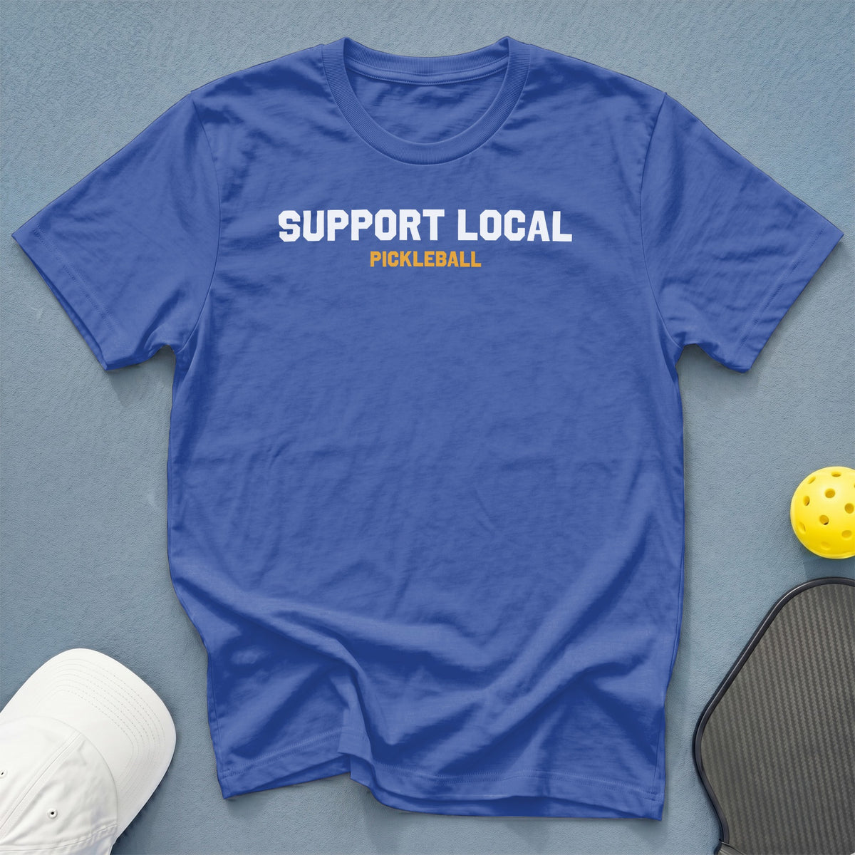 Blue t-shirt with white text "SUPPORT LOCAL" and orange text "PICKLEBALL".