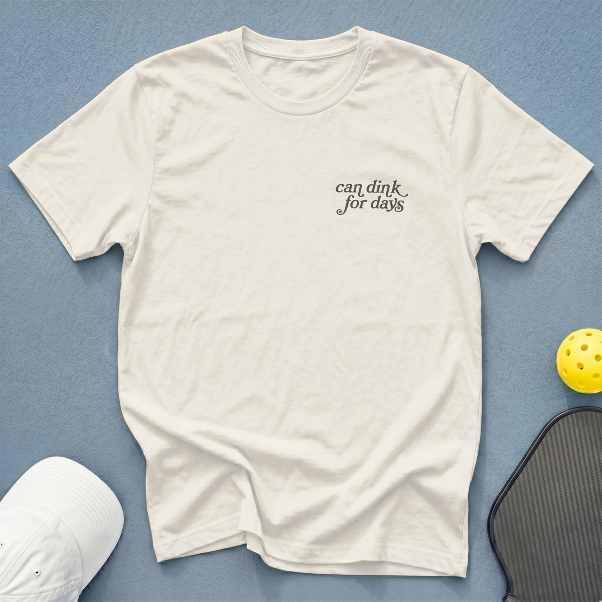 Cream t-shirt with "can dink for days" text, pickleball paddle, and ball.