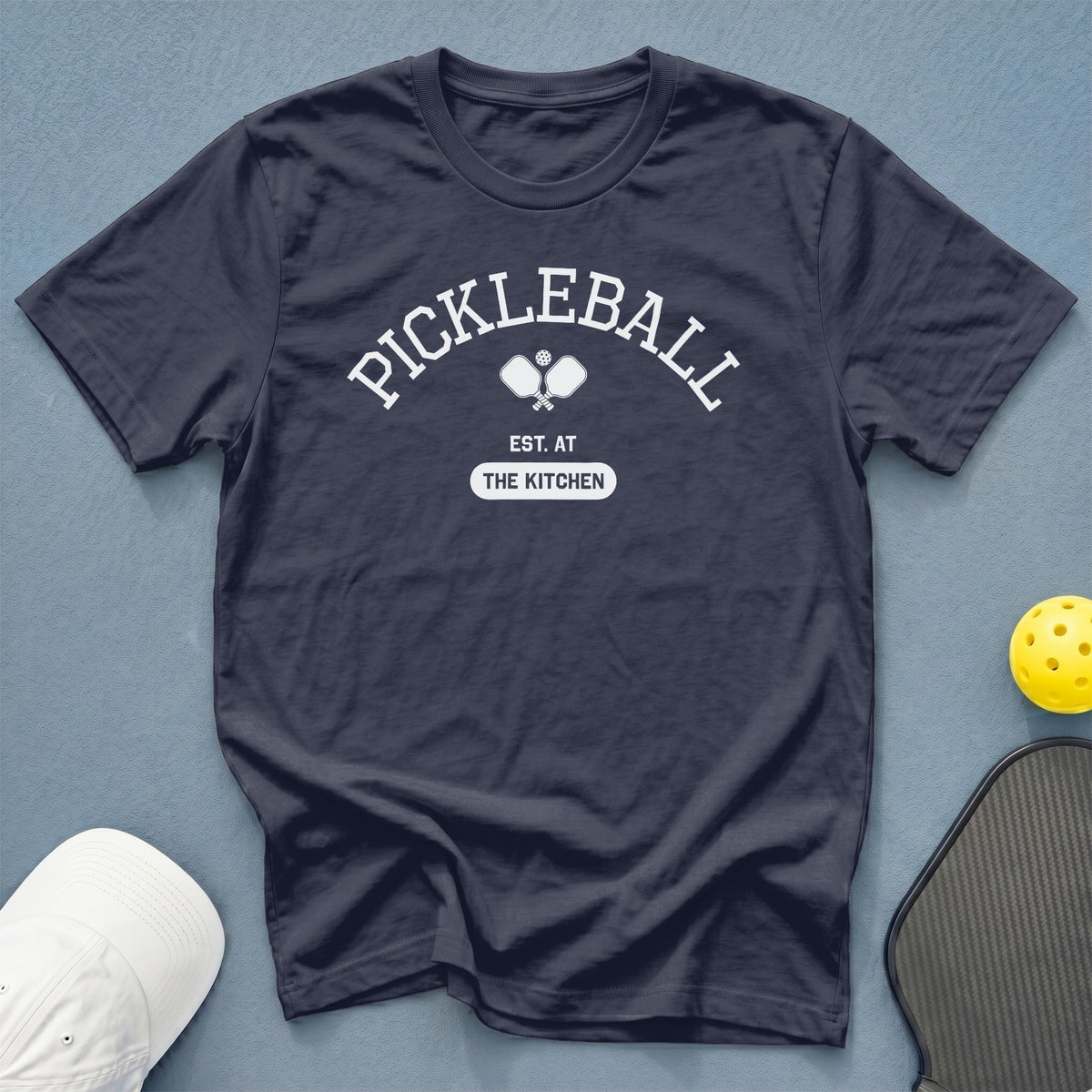 Dark blue t-shirt with "PICKLEBALL EST. AT THE KITCHEN" graphic.