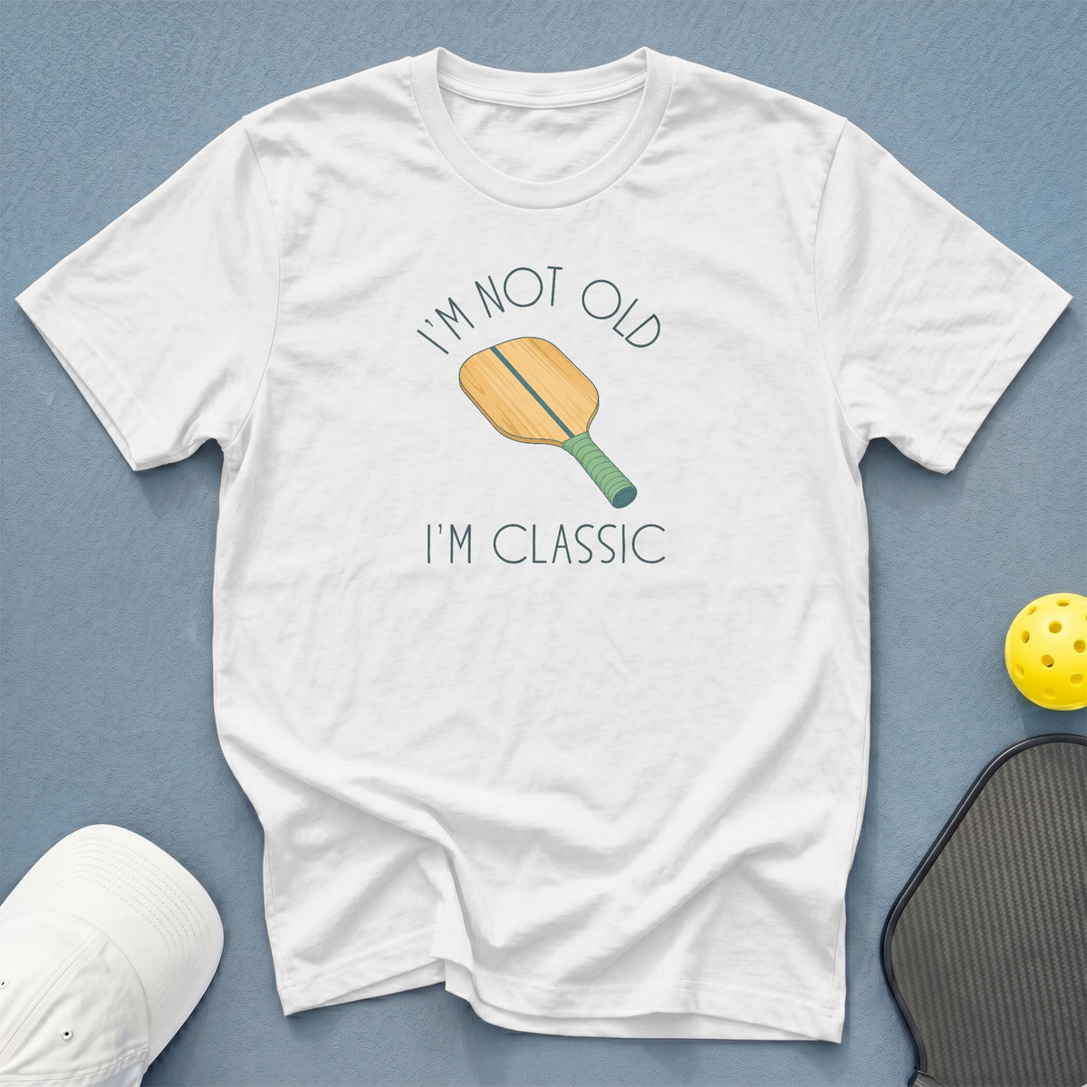 White t-shirt with "I'm not old I'm classic" and pickleball paddle graphic.