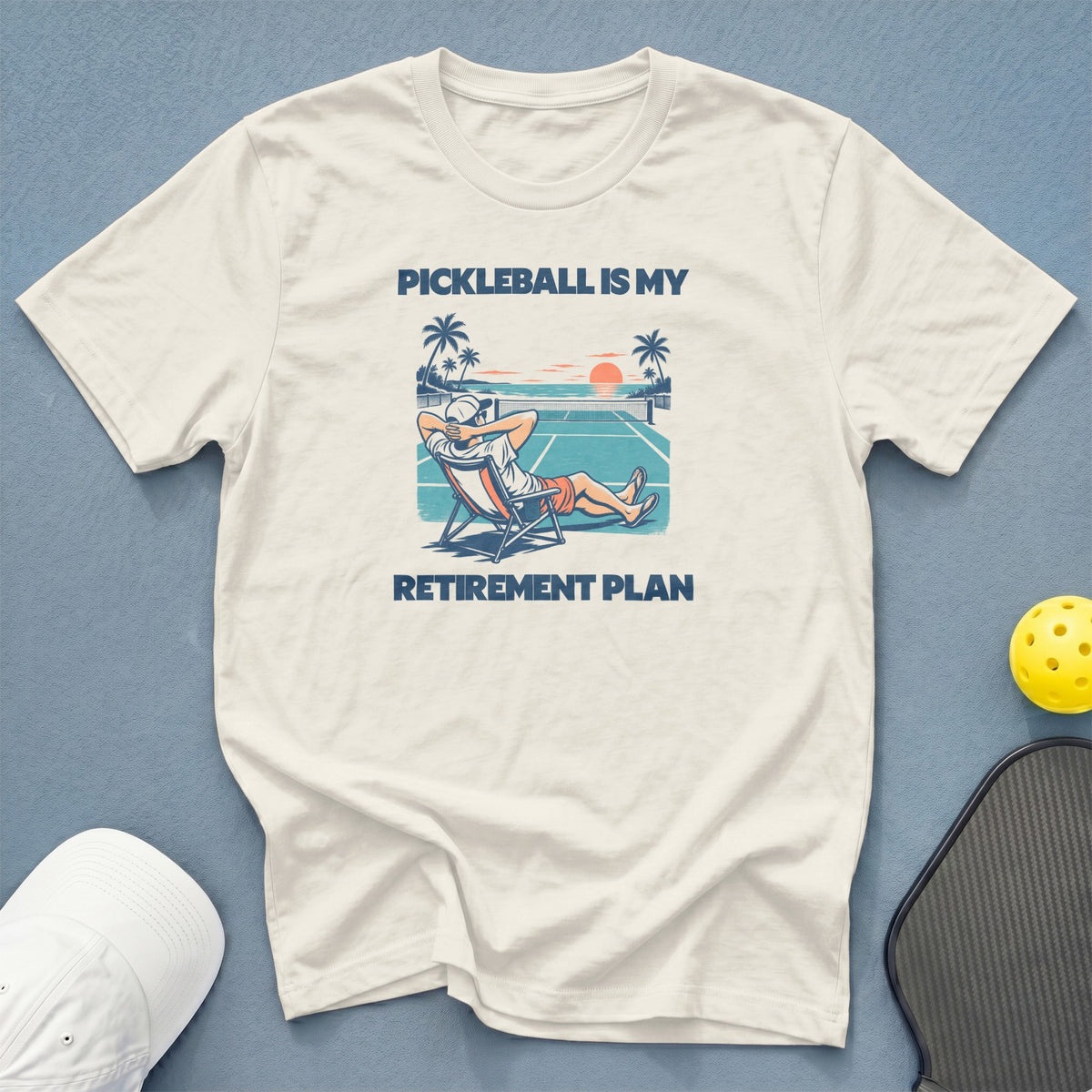White t-shirt with "Pickleball is my retirement plan" graphic.