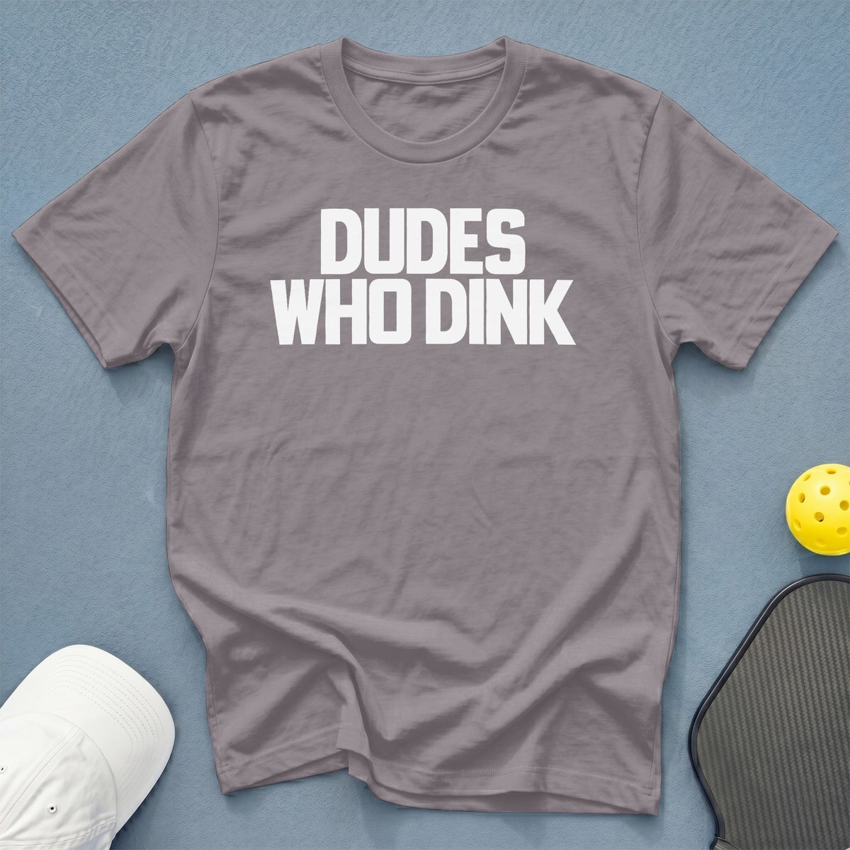 Gray t-shirt with white text reading "DUDE WHO DINK" next to pickleball gear.