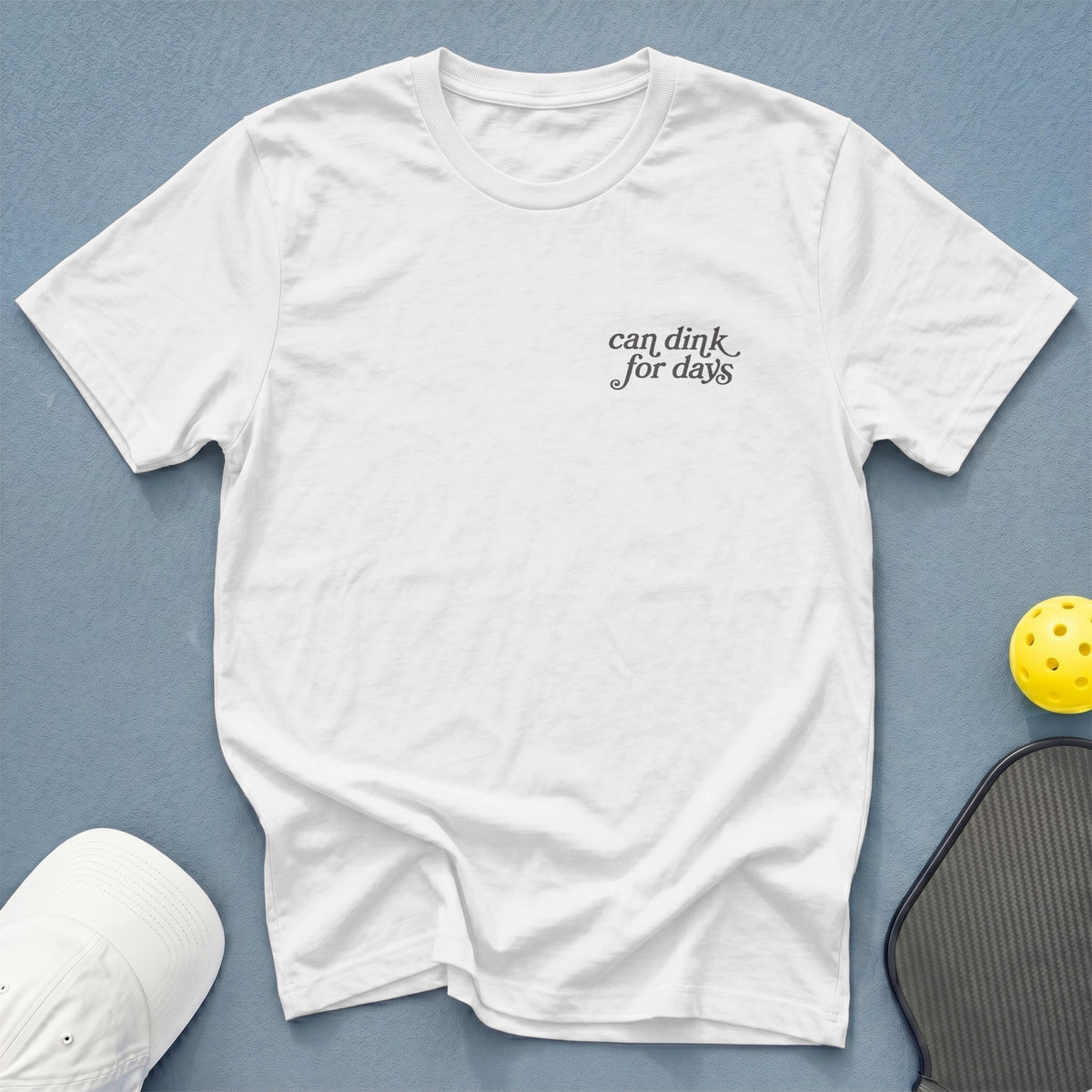 White t-shirt with "can dink for days" text and pickleball gear.