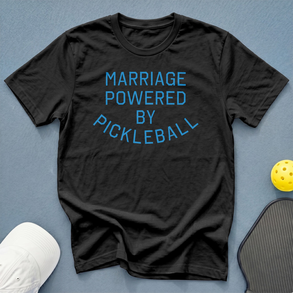 Black t-shirt with blue text that reads "MARRIAGE POWERED BY PICKLEBALL."