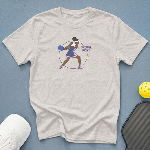 Light grey t-shirt with a graphic of a woman playing pickleball and the text "DROP & DRIVE".