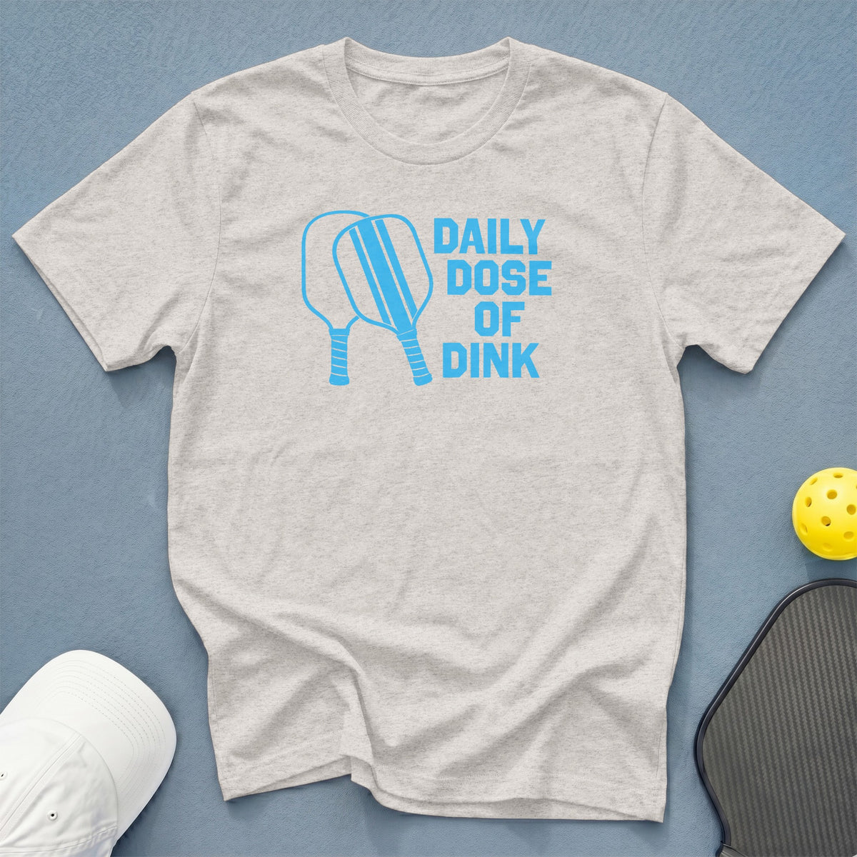 Light grey t-shirt with blue graphic text "DAILY DOSE OF DINK".