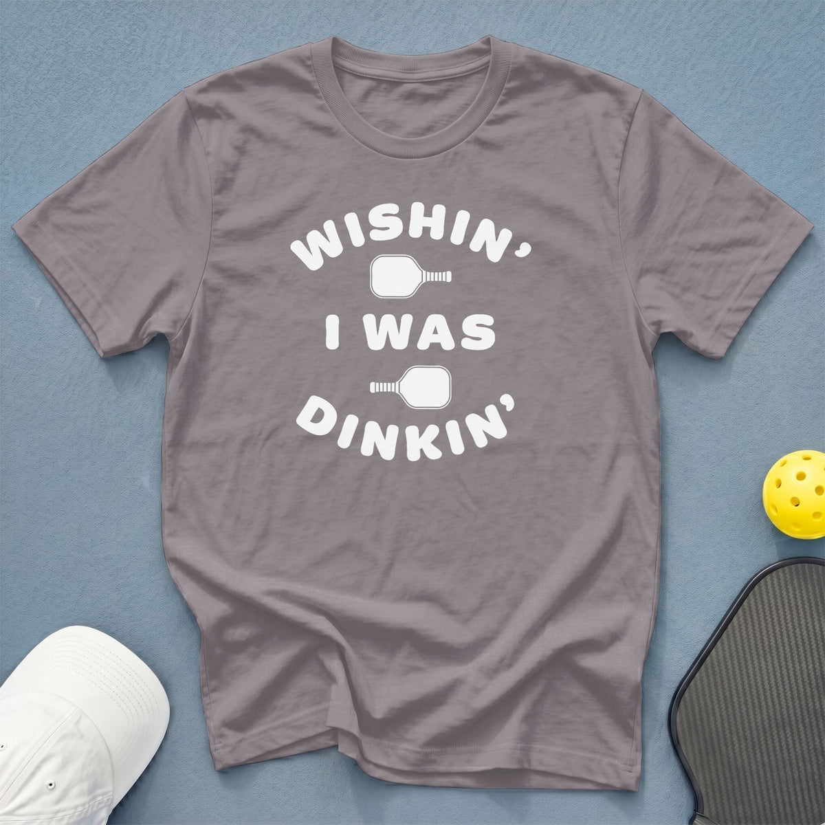 Gray t-shirt with white text "WISHIN, I WAS, DINKIN'" and pickleball icons.