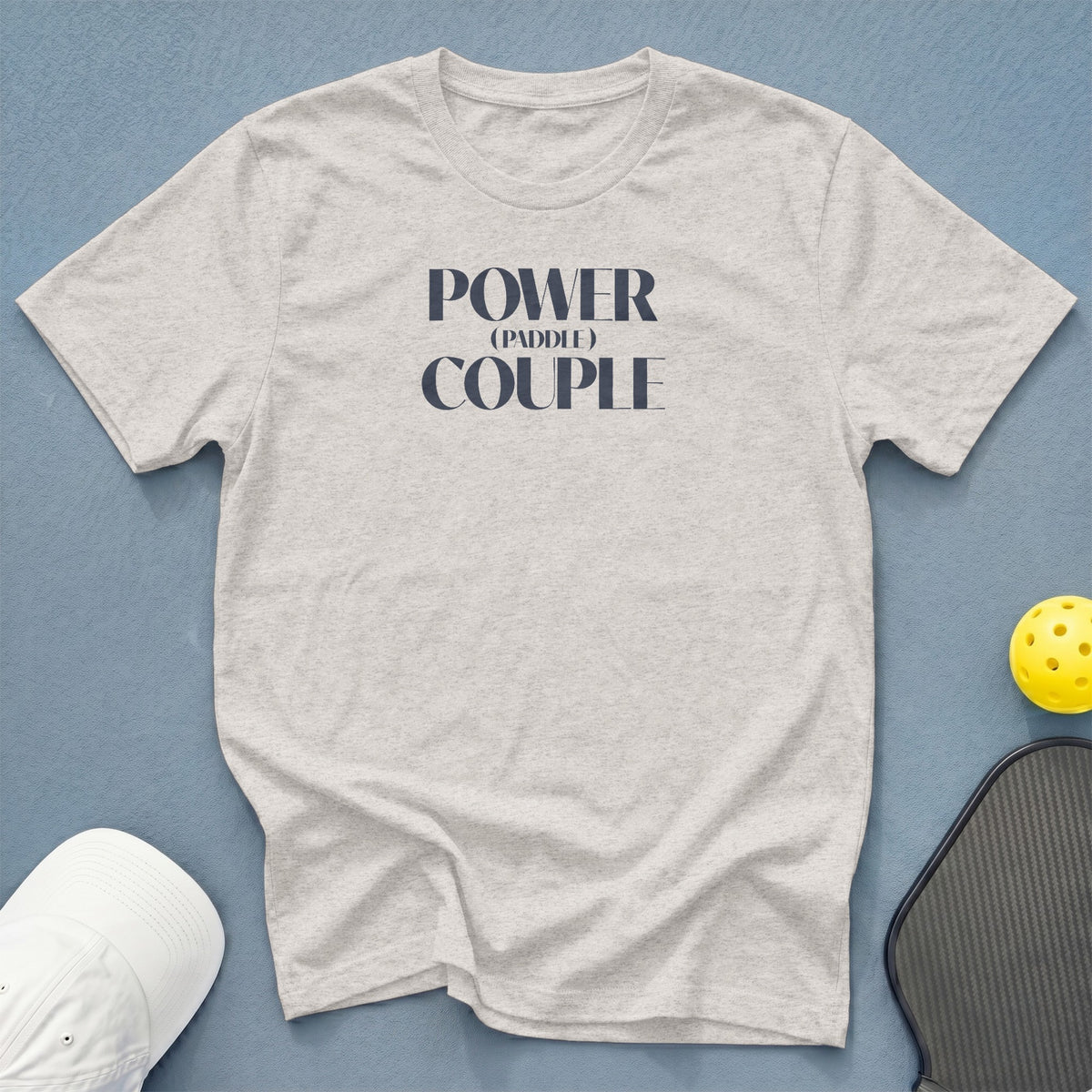 Light gray t-shirt with "POWER (PADDLE) COUPLE" text in navy blue.