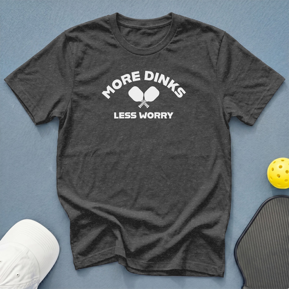 Dark grey t-shirt with white text "MORE DINKS LESS WORRY" and pickleball paddles.