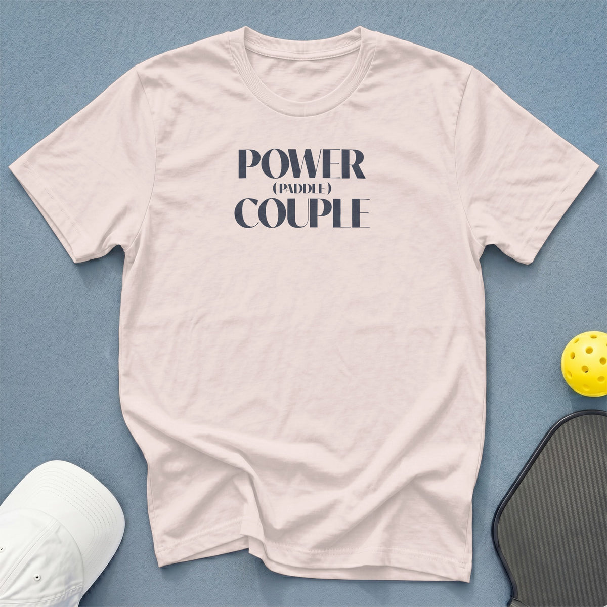 Pale pink t-shirt with "Power (Paddle) Couple" graphic, pickleball paddle, and yellow ball.