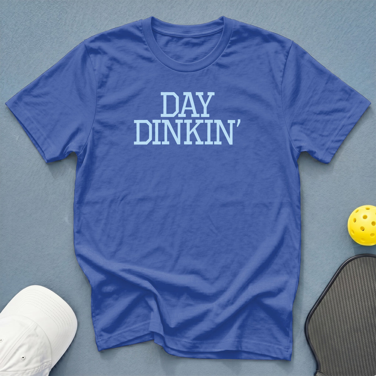 Blue t-shirt with "DAY DINKIN'" text, pickleball paddle, and ball.