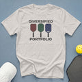 Light grey t-shirt with text "DIVERSIFIED PORTFOLIO" and three colorful pickleball paddles.