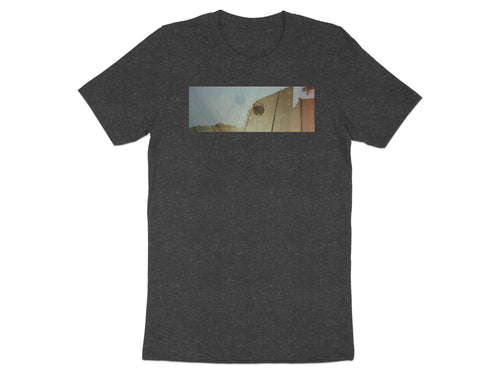 Dark gray t-shirt with a horizontal image of a wine glass on a wooden surface.