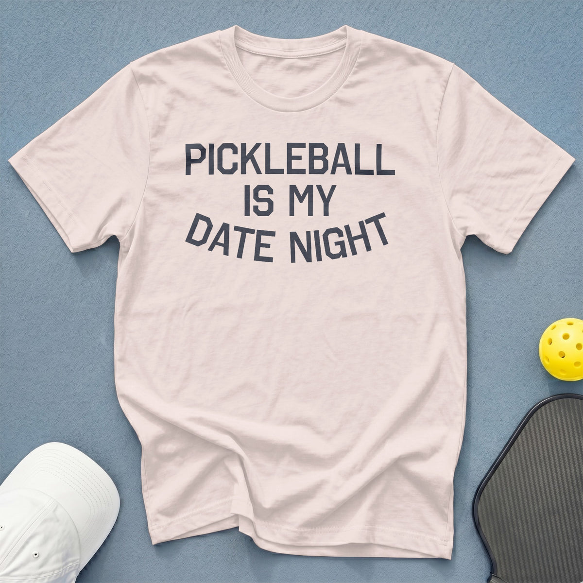 White t-shirt with text "PICKLEBALL IS MY DATE NIGHT" and pickleball accessories.