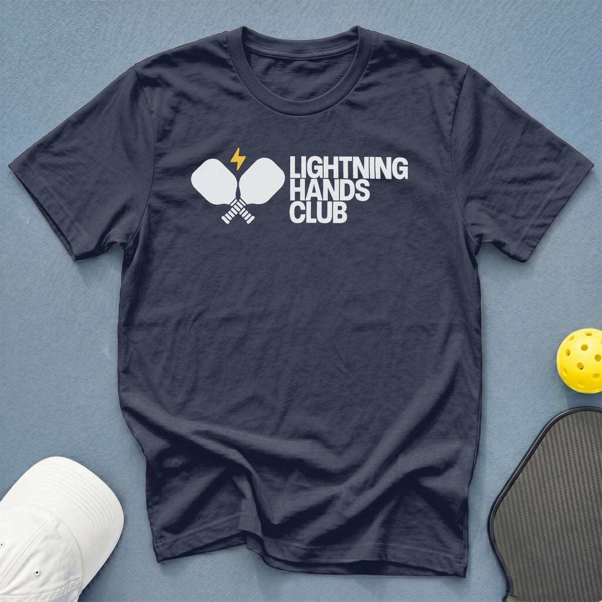 Navy t-shirt with white "Lightning Hands Club" text and pickleball paddles graphic.