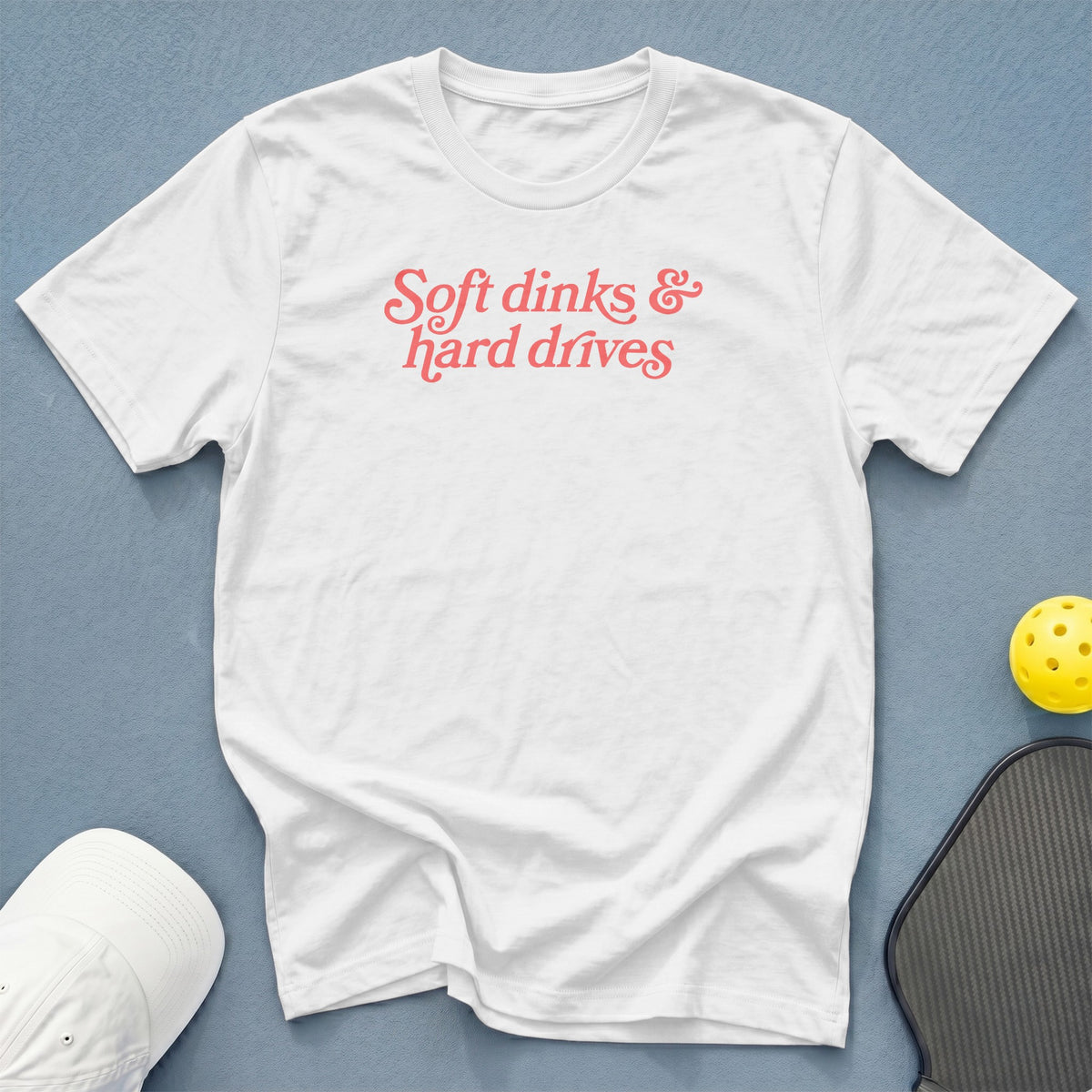 White t-shirt with "Soft dinks & hard drives" text in coral.