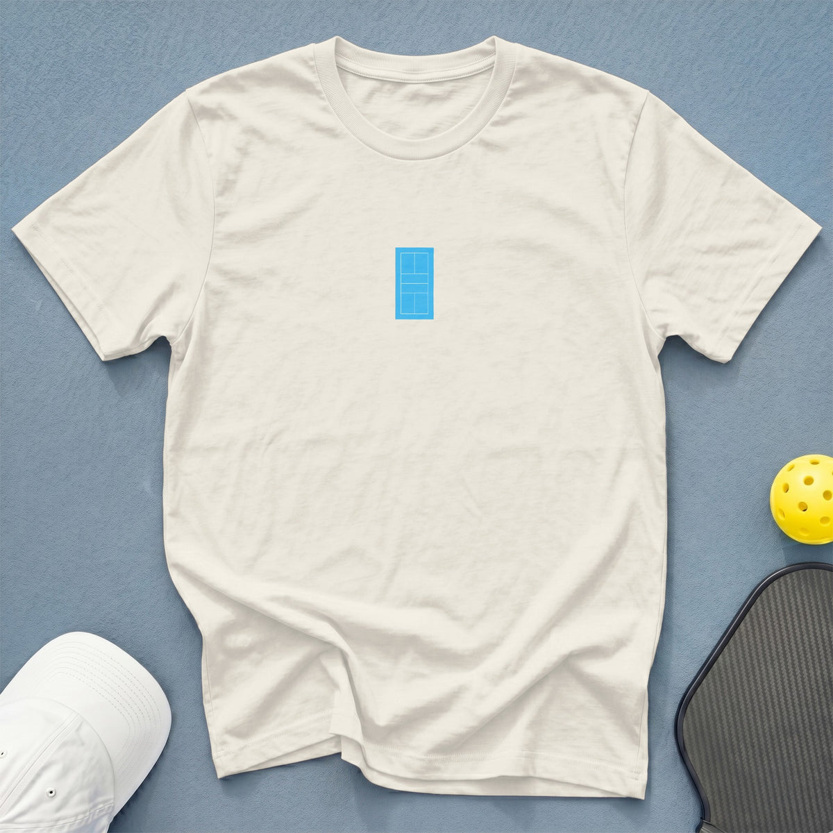 Cream t-shirt with a blue pickleball court graphic on the chest.