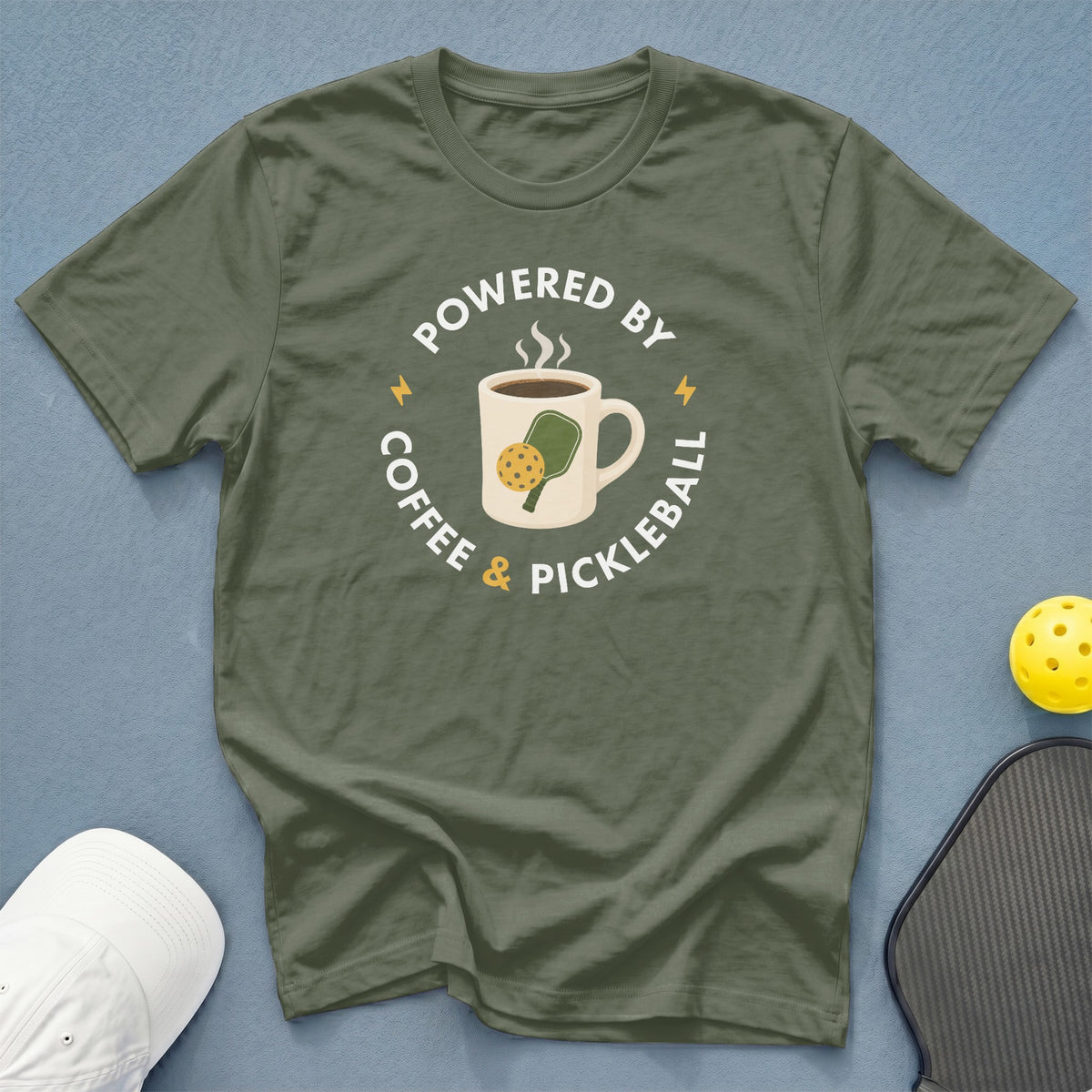 Olive green t-shirt with "Powered by Coffee & Pickleball" graphic.