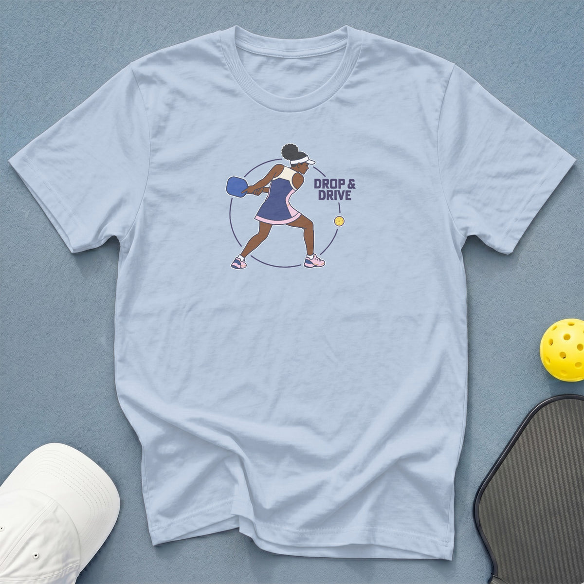 Light blue t-shirt with "DROP & DRIVE" and a pickleball player graphic.
