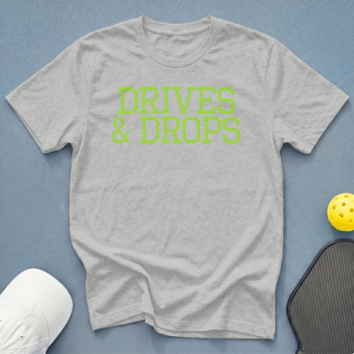 Grey t-shirt with neon green text that reads "DRIVES & DROPS".