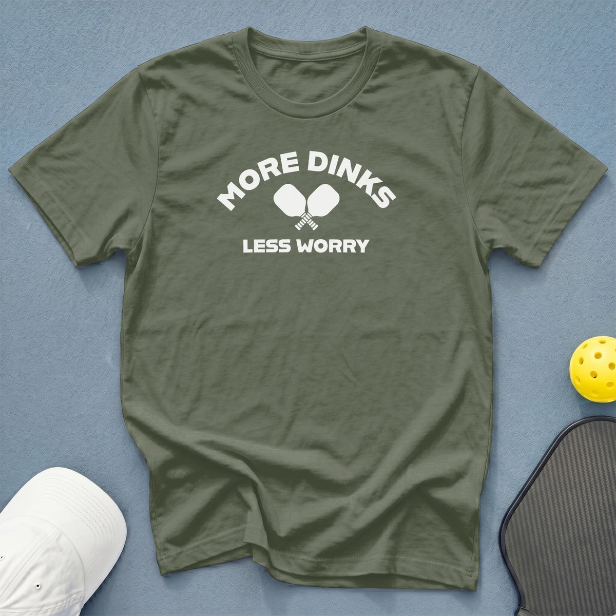Green t-shirt with white text "MORE DINKS LESS WORRY" and pickleball paddles.