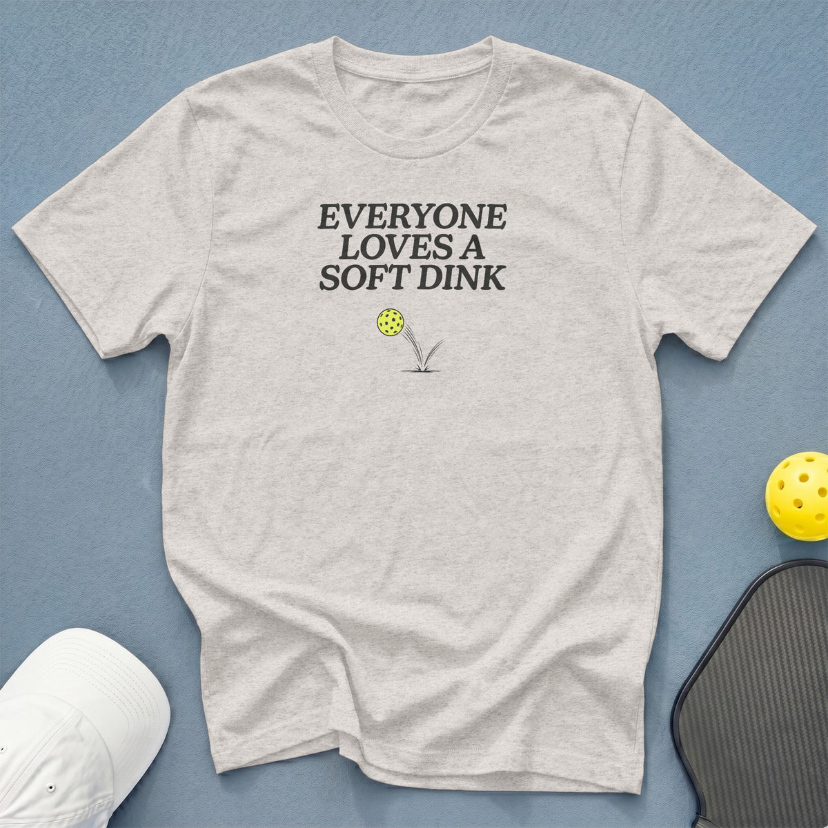 Light grey t-shirt with text "EVERYONE LOVES A SOFT DINK" and pickleball graphic.