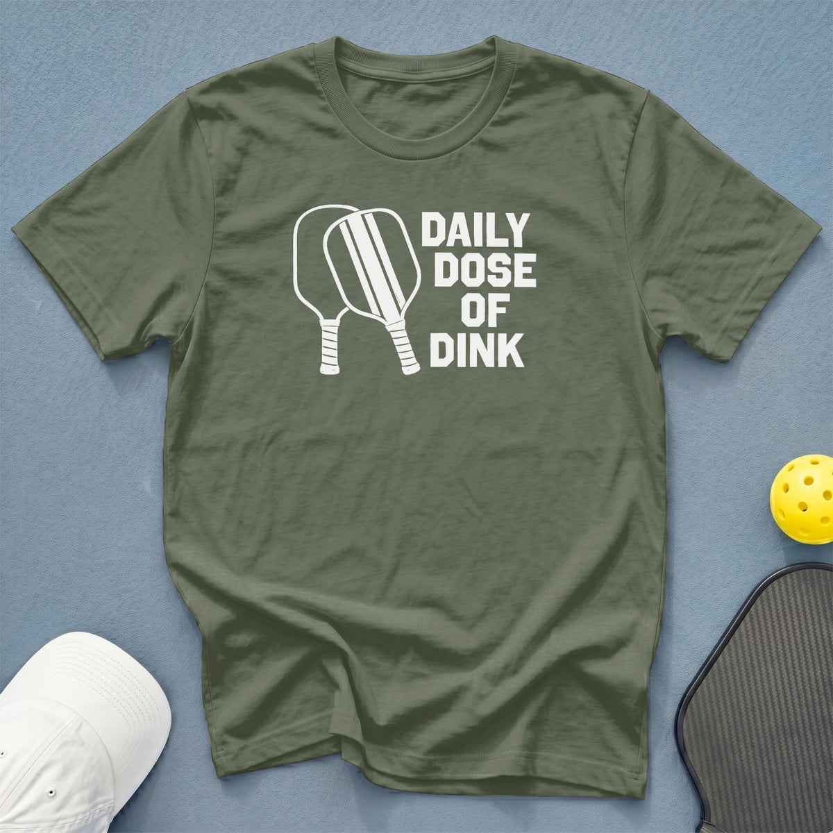 Green t-shirt with white text "DAILY DOSE OF DINK" and pickleball paddles.