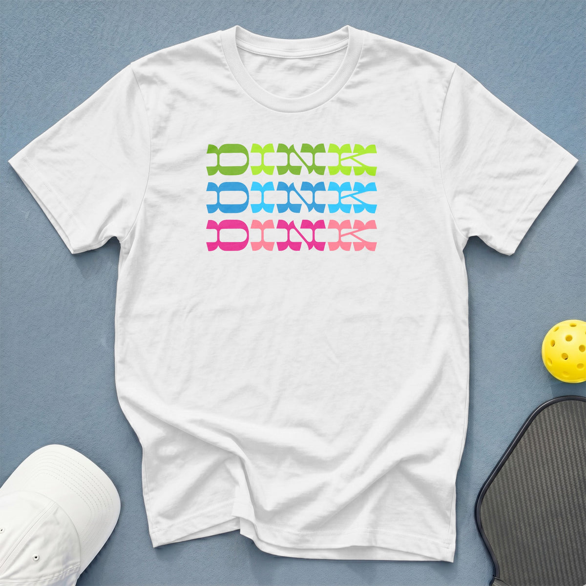 White t-shirt with "Dink" in stacked green, blue, and pink lettering.