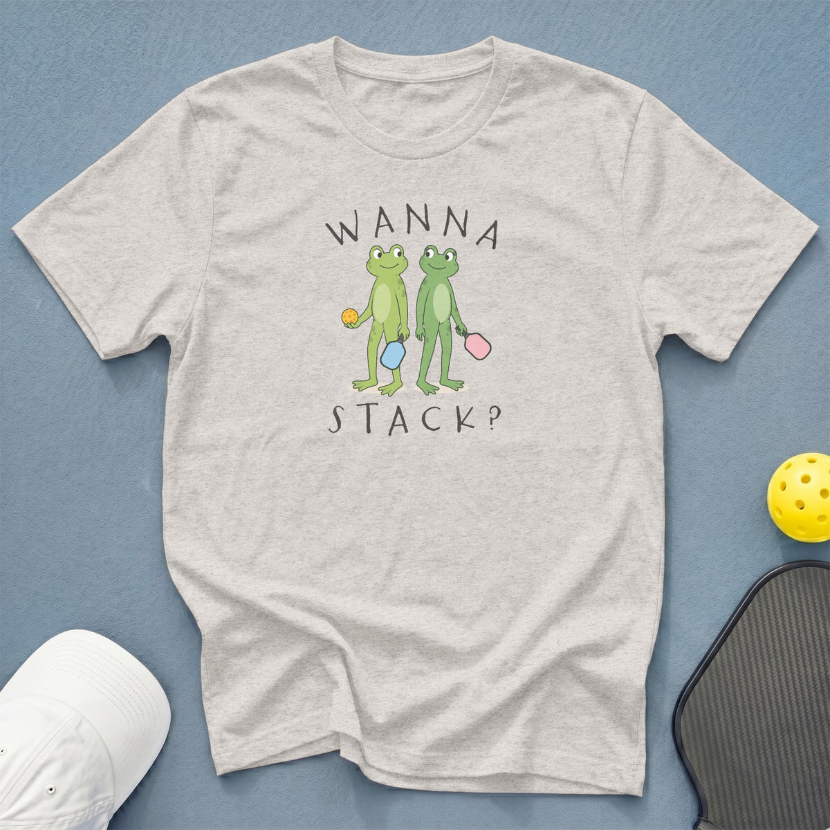 T-shirt with two cartoon frogs holding pickleball paddles and balls.