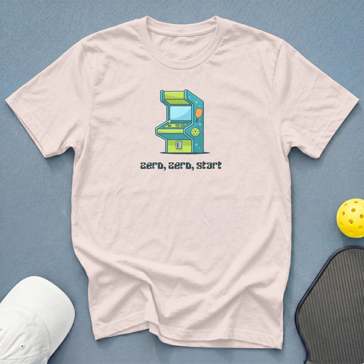 Pink t-shirt with a retro arcade game graphic and text "zero, zero, start".