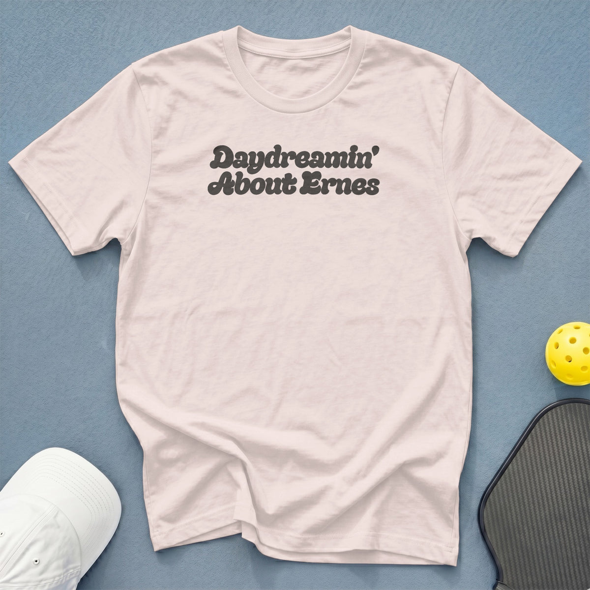 Light pink t-shirt with "Daydreamin' About Ernes" text, pickleball paddle, and yellow ball.