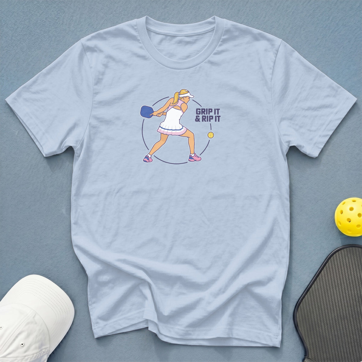 Light blue t-shirt with a pickleball player graphic and text "GRIP IT & RIP IT".