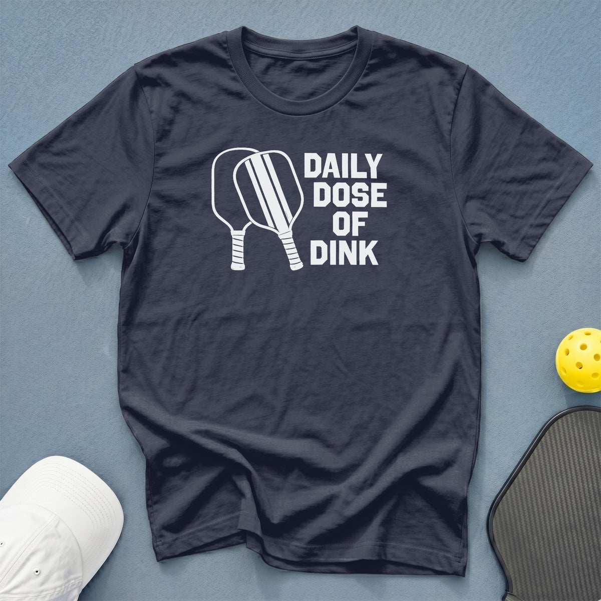 Navy t-shirt with "Daily Dose of Dink" text and pickleball paddles graphic.