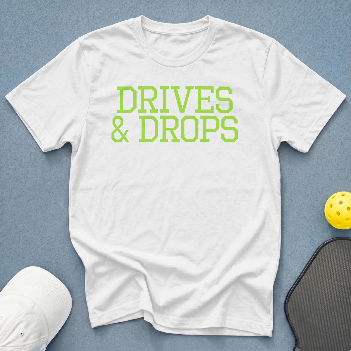 White t-shirt with green text that says "DRIVES & DROPS".