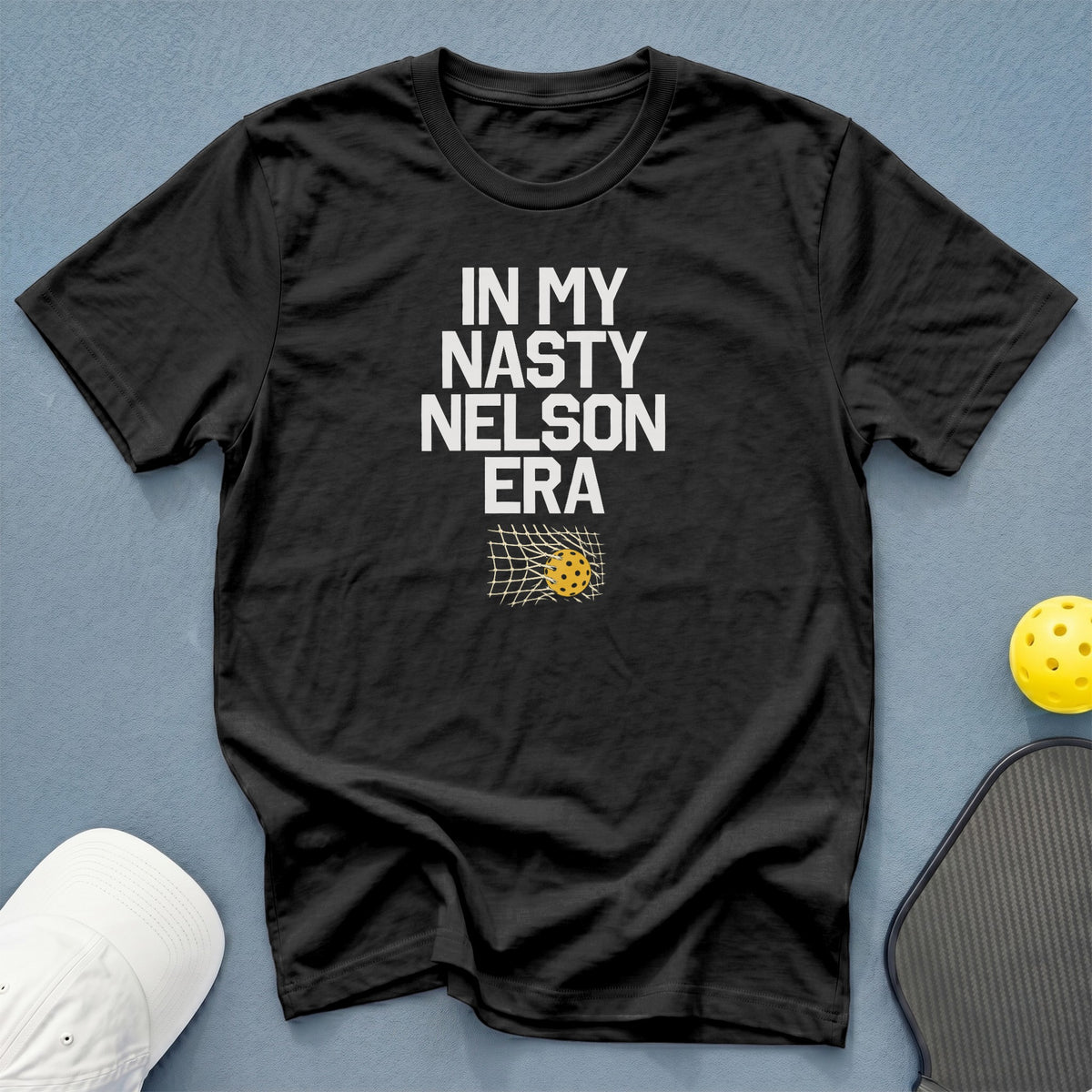Black t-shirt with "IN MY NASTY NELSON ERA" text and pickleball net graphic.