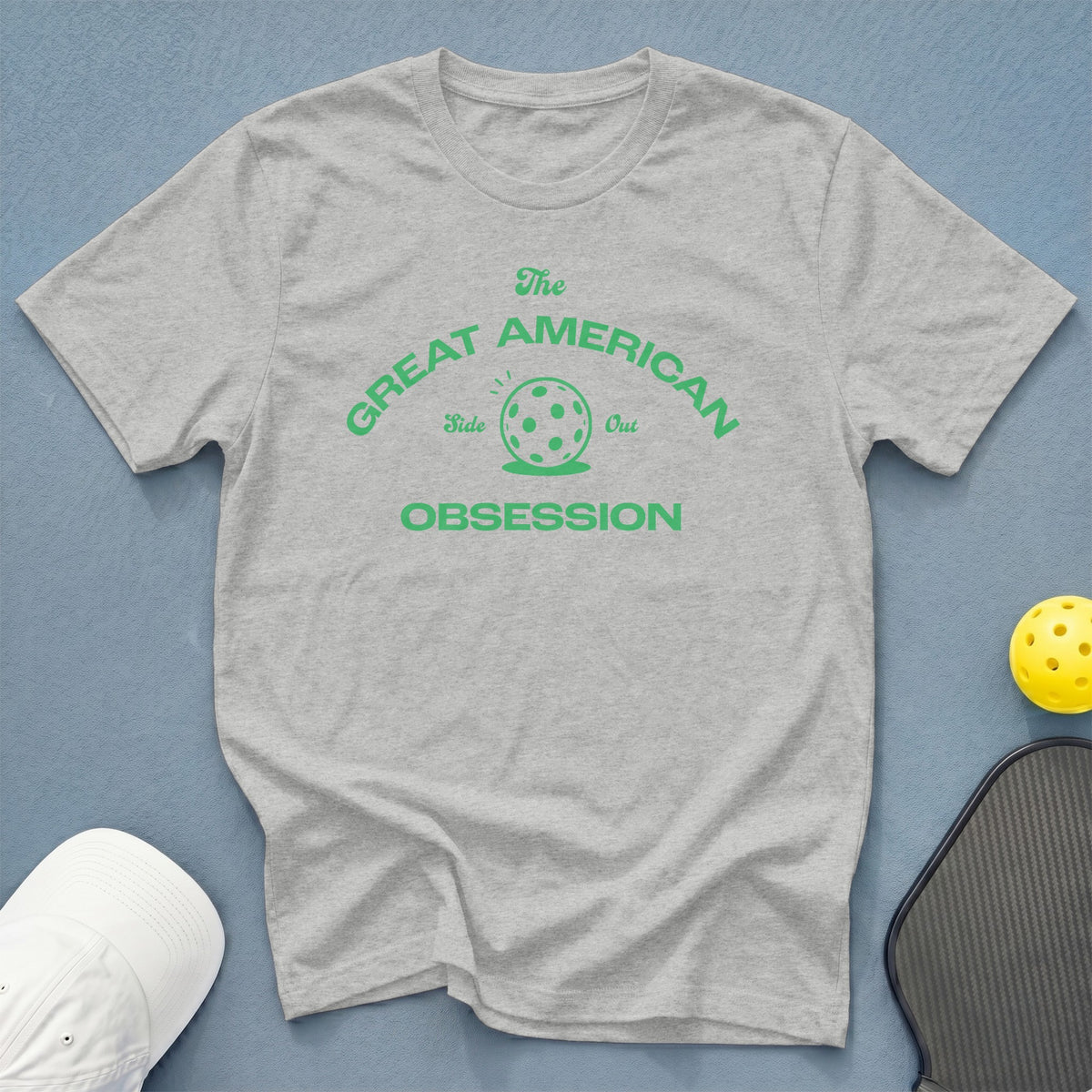 Light grey t-shirt with green text "The Great American Obsession" and pickleball graphic.
